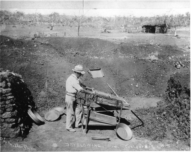 Caption: a man pushing a wheelbarrow (0.53 confidence)<br />Labels: outdoor, ground, transport, old